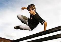 Boy jumping over fence