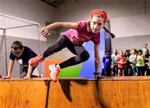 Girl jumping over a wall