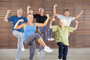 A group of seniors flex their arm muscles after finishing a Zumba Gold program