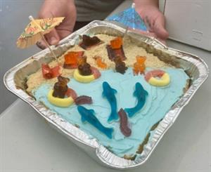 A child shows their food creation, a beach scene with gummy sharks, and gummy bears floating in the water.