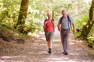 Two seniors' hike on a dirt path together