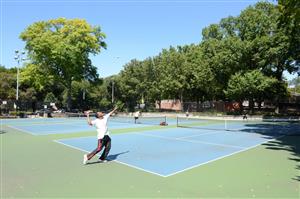 Adults play tennis in the park