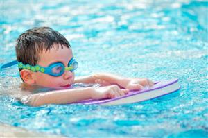 A child swims across the pool during swim lessons