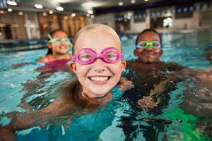 Children smile and laugh during swim lessons in the pool