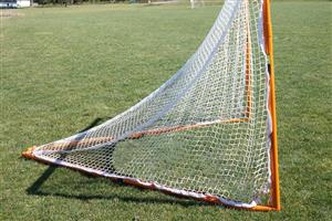 A lacrosse net sitting on a field